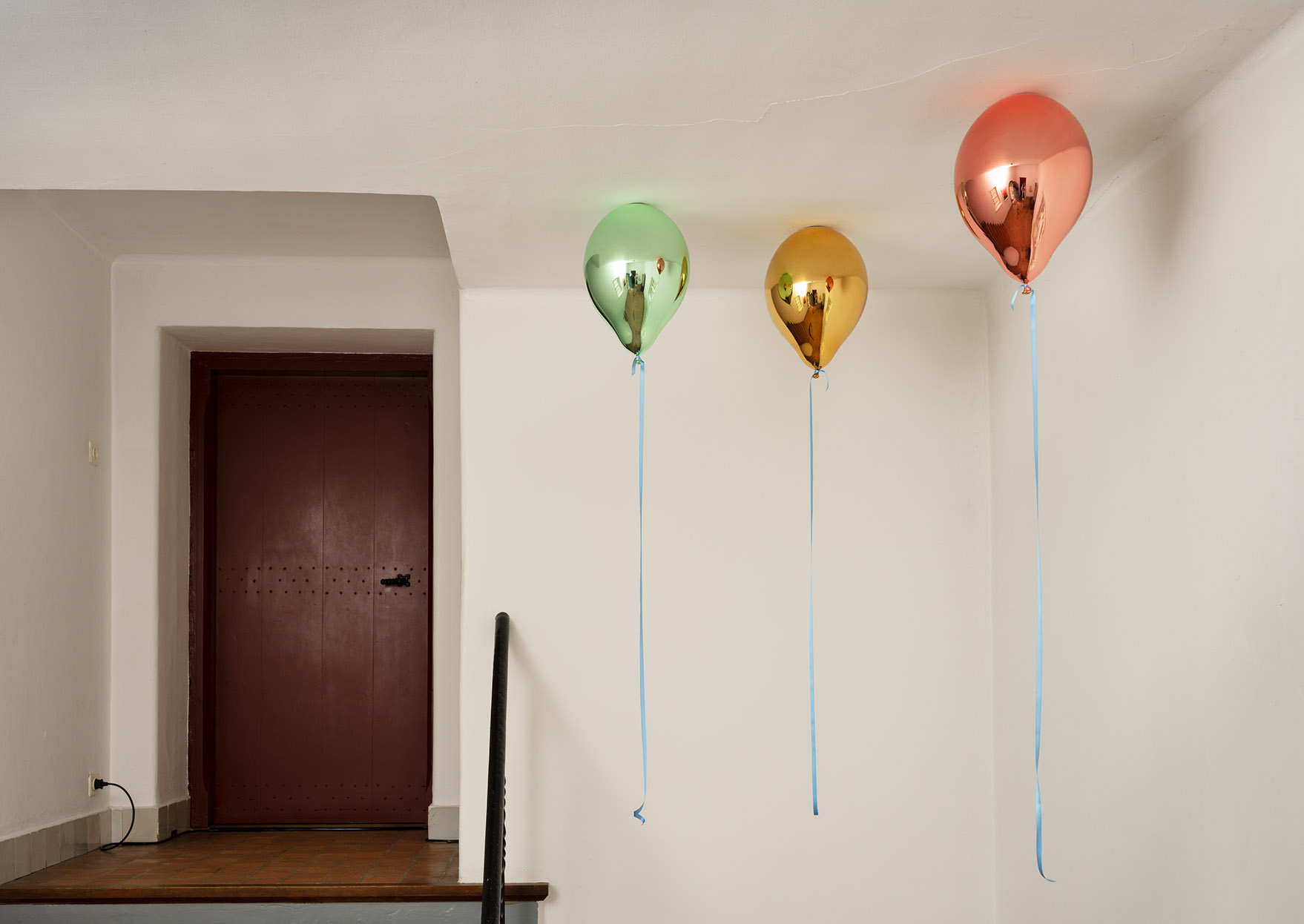 drie gekleurde balonnen hangen aan het plafond
